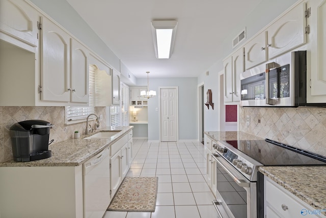 kitchen with a sink, visible vents, backsplash, appliances with stainless steel finishes, and light tile patterned floors