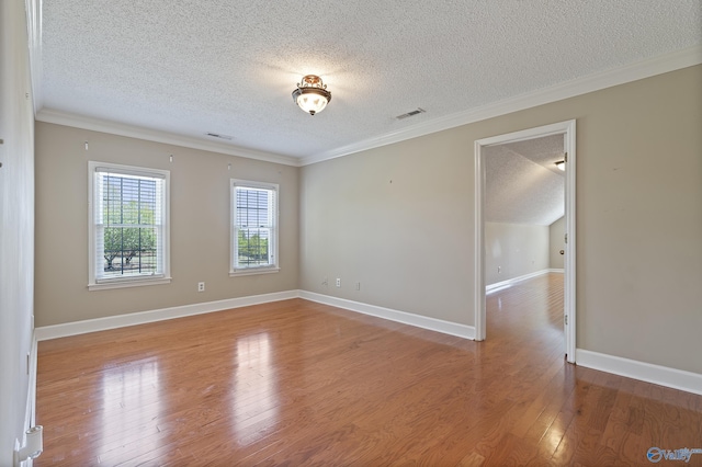 unfurnished room with crown molding, wood finished floors, a textured ceiling, and visible vents