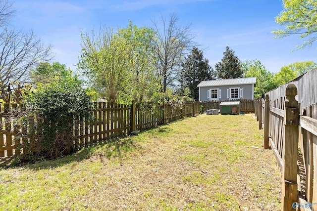 view of yard with a fenced backyard and an outbuilding