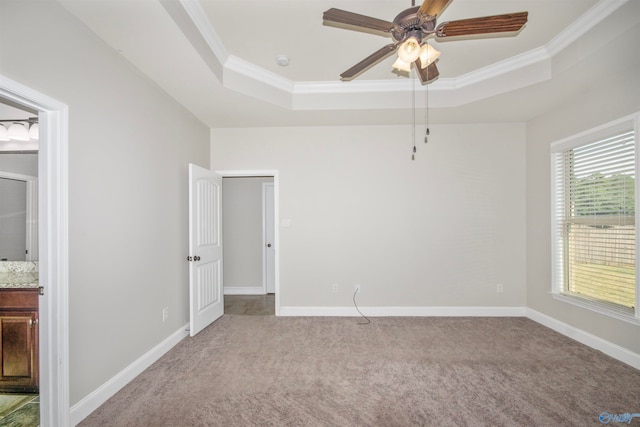 carpeted empty room with ornamental molding, a tray ceiling, and ceiling fan