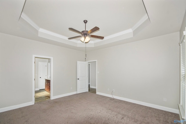 unfurnished bedroom with a tray ceiling, carpet floors, and ceiling fan