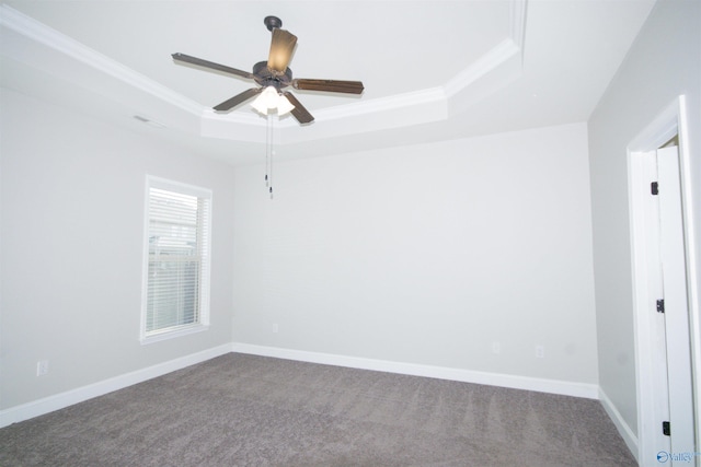 empty room with crown molding, carpet floors, a tray ceiling, and ceiling fan