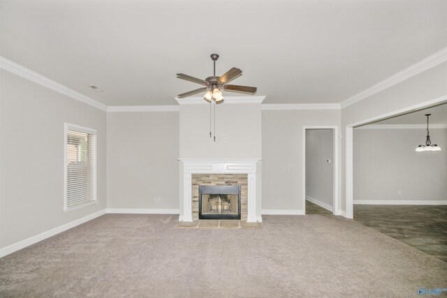 unfurnished living room featuring ornamental molding, a tiled fireplace, carpet flooring, and ceiling fan