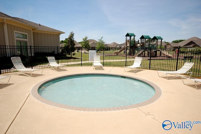 view of swimming pool featuring a patio area, a playground, and a yard