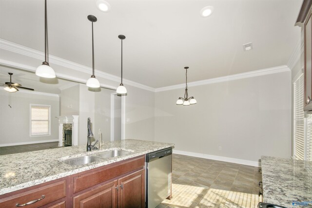 kitchen featuring a stone fireplace, hanging light fixtures, sink, stainless steel dishwasher, and light stone counters