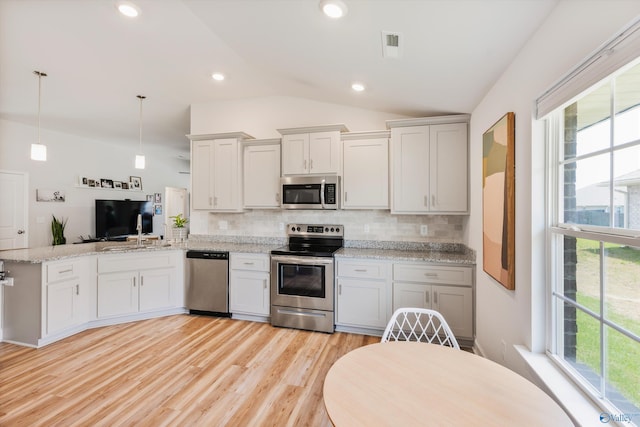 221 Alonzo Toney Dr, Madison, AL 35756 - kitchen with stainless steel appliances, vaulted ceiling, a peninsula, healthy amount of natural light, and backsplash