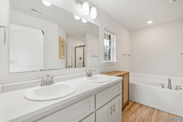 221 Alonzo Toney Dr, Madison, AL 35756 - full bathroom with a shower stall, double vanity, a garden tub, and wood finished floors