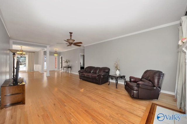 living room with ceiling fan with notable chandelier, ornamental molding, and light wood-type flooring