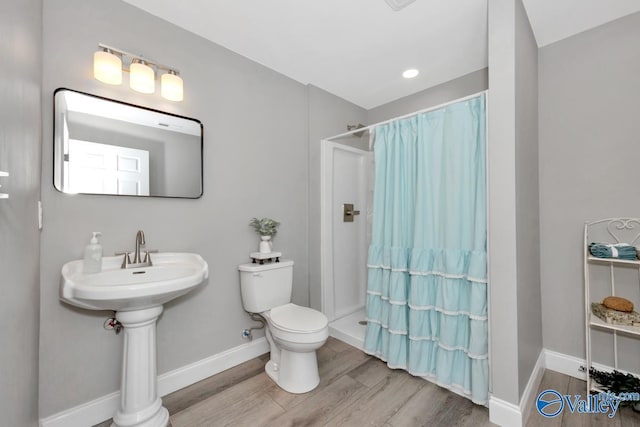 bathroom with a shower with curtain, toilet, and hardwood / wood-style flooring