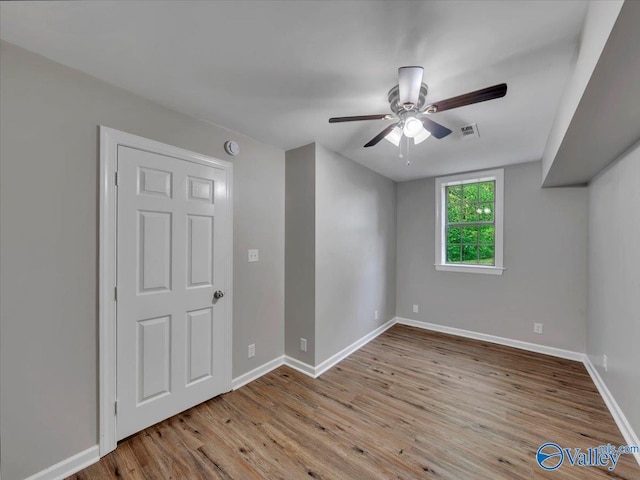 unfurnished room featuring visible vents, a ceiling fan, baseboards, and wood finished floors