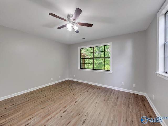 unfurnished room with baseboards, ceiling fan, and wood finished floors