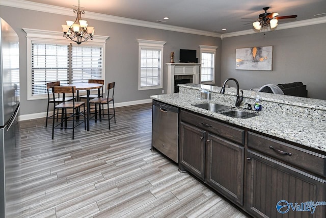 kitchen featuring ceiling fan with notable chandelier, dark brown cabinetry, stainless steel appliances, sink, and hanging light fixtures