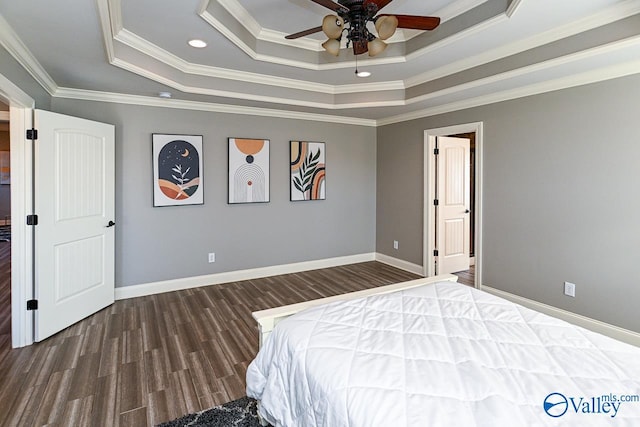 unfurnished bedroom featuring ceiling fan, dark hardwood / wood-style floors, crown molding, and a tray ceiling