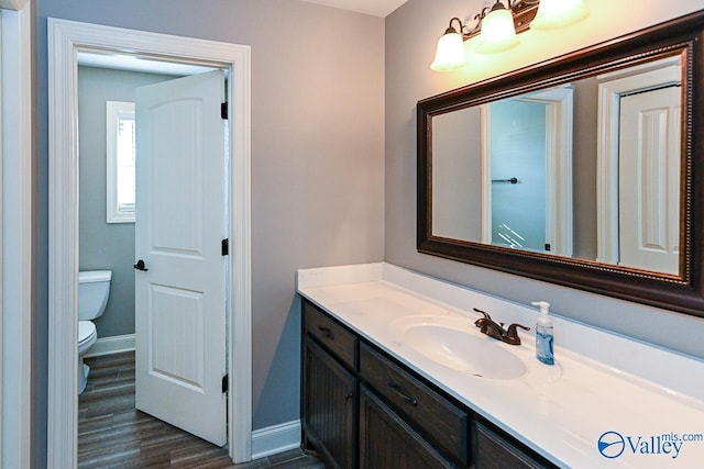 bathroom featuring hardwood / wood-style floors, vanity, and toilet