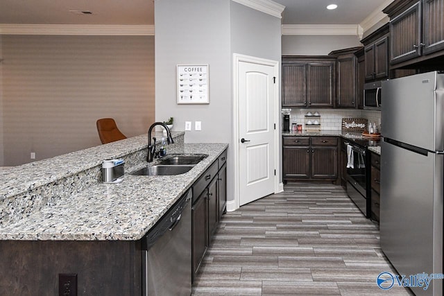 kitchen featuring appliances with stainless steel finishes, backsplash, light stone counters, crown molding, and sink