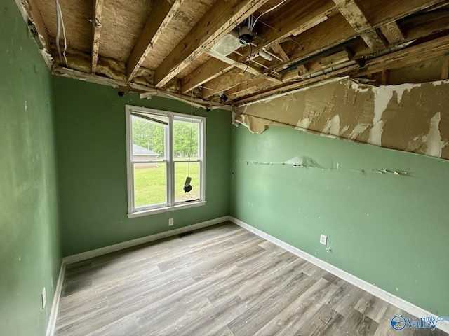 basement featuring baseboards and wood finished floors