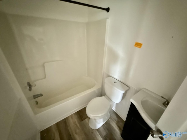 bathroom with wood finished floors, toilet, shower / bath combination, and vanity