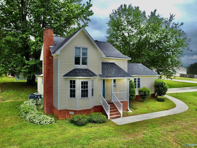 traditional-style house with a chimney, a shingled roof, a front lawn, and central AC unit