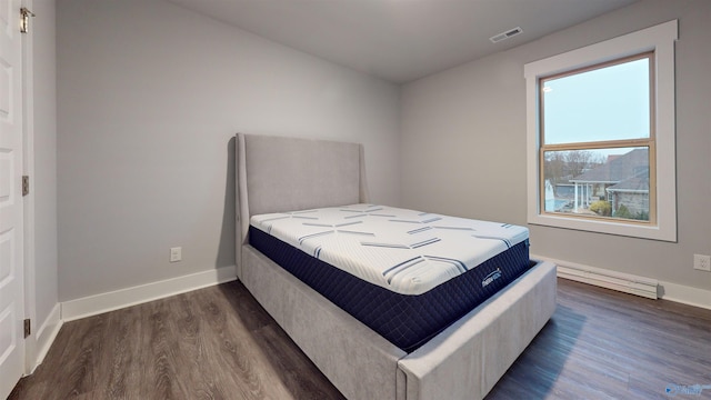 bedroom with dark wood-type flooring and multiple windows