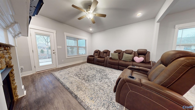 living room with a fireplace, dark hardwood / wood-style floors, and ceiling fan