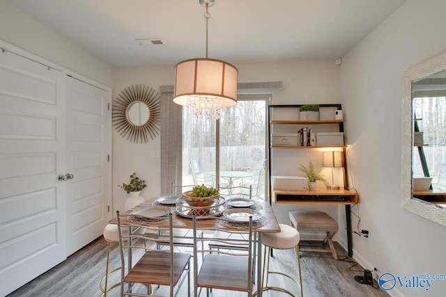 dining room with visible vents, baseboards, and wood finished floors