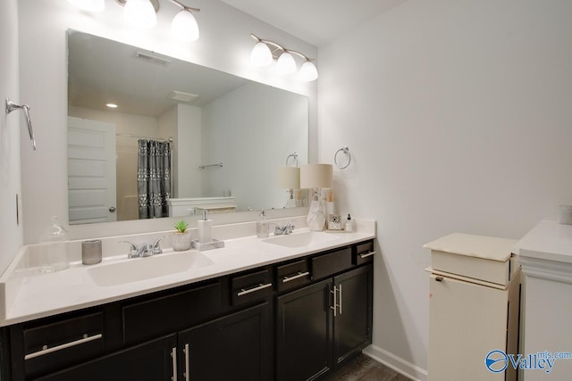 bathroom featuring double vanity, a shower with curtain, visible vents, and a sink