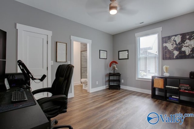 office area with a ceiling fan, baseboards, visible vents, and wood finished floors
