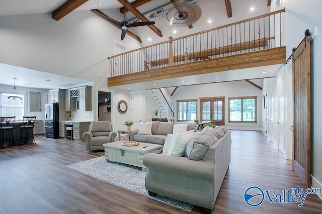 living room with stairs, ceiling fan, wood finished floors, and high vaulted ceiling