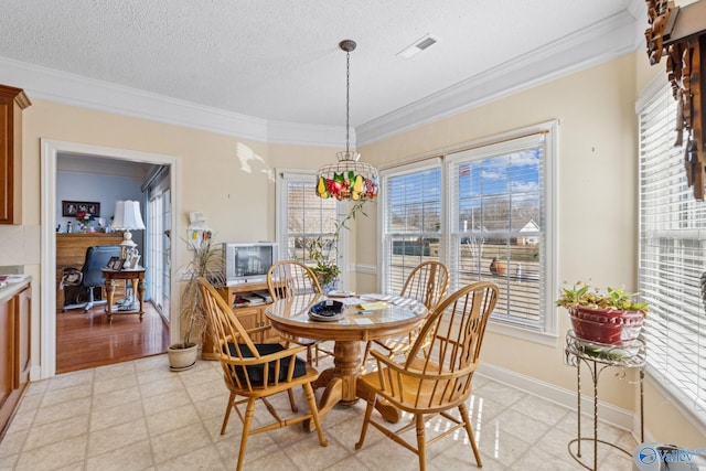 dining area with ornamental molding and a textured ceiling