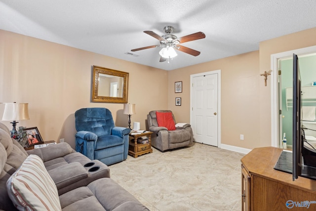 living room with ceiling fan and a textured ceiling