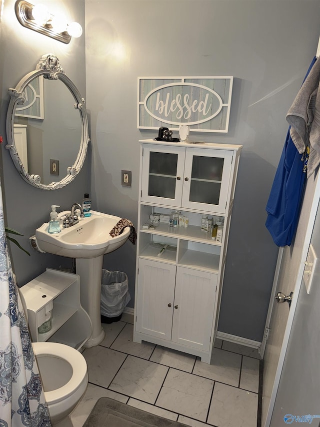 bathroom featuring toilet and baseboards