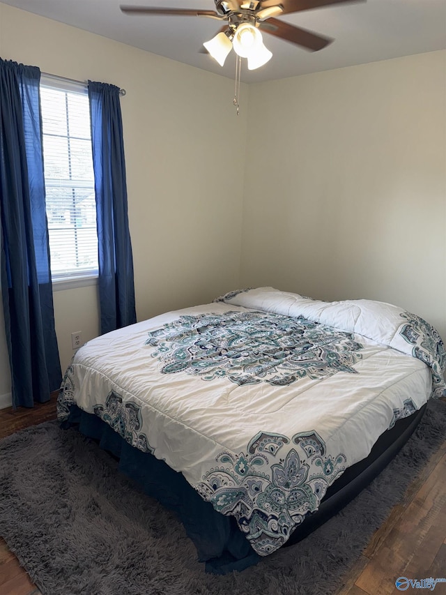 bedroom with ceiling fan and dark wood finished floors