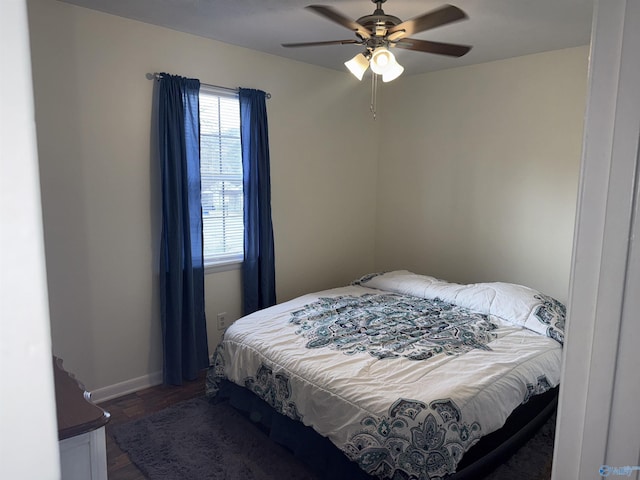 bedroom with dark wood-style floors, ceiling fan, and baseboards