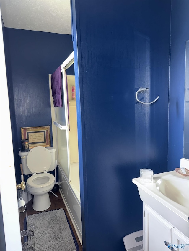 full bathroom with toilet, shower / bath combination with glass door, and vanity