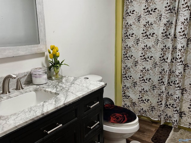 bathroom with hardwood / wood-style floors, vanity, and toilet