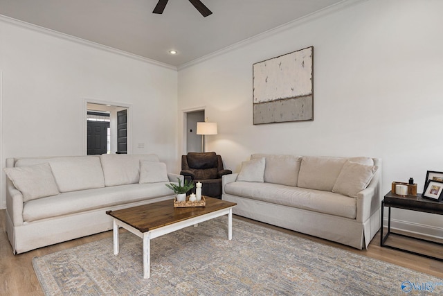 living area featuring ornamental molding, wood finished floors, and ceiling fan