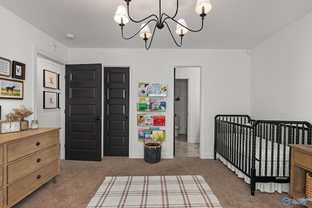 bedroom featuring baseboards, a crib, carpet, and an inviting chandelier