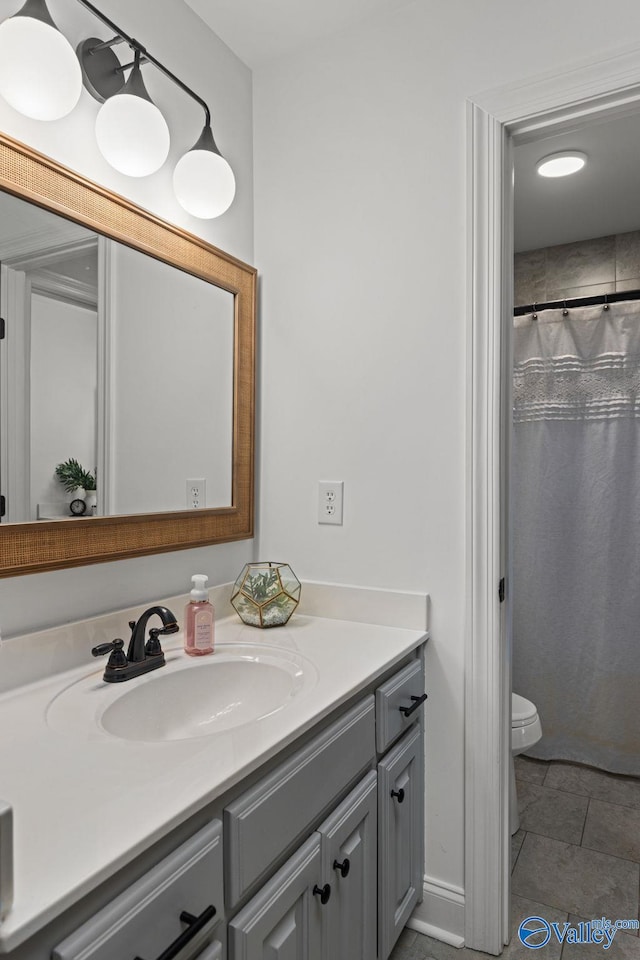 bathroom with vanity, tile patterned floors, curtained shower, and toilet