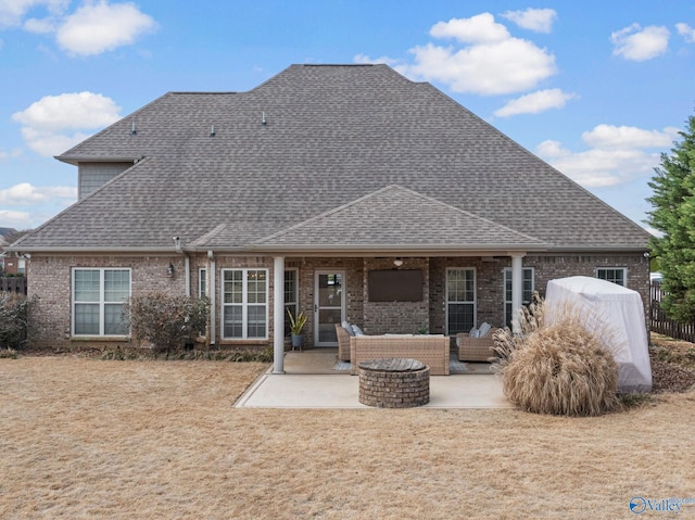 back of house featuring a patio area, an outdoor living space with a fire pit, brick siding, and a shingled roof