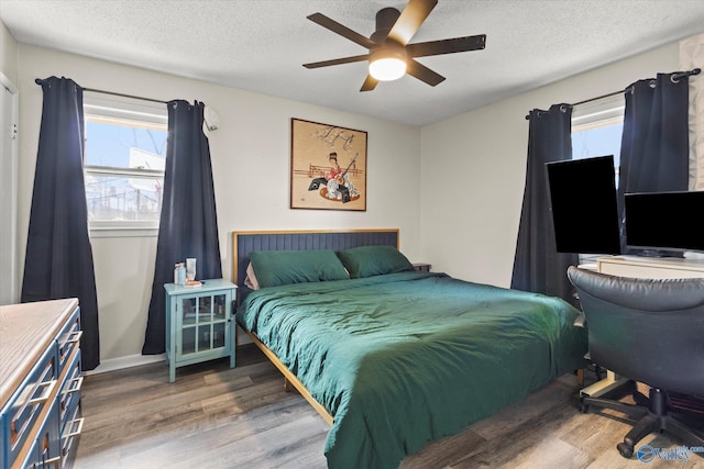 bedroom featuring ceiling fan, a textured ceiling, and wood finished floors