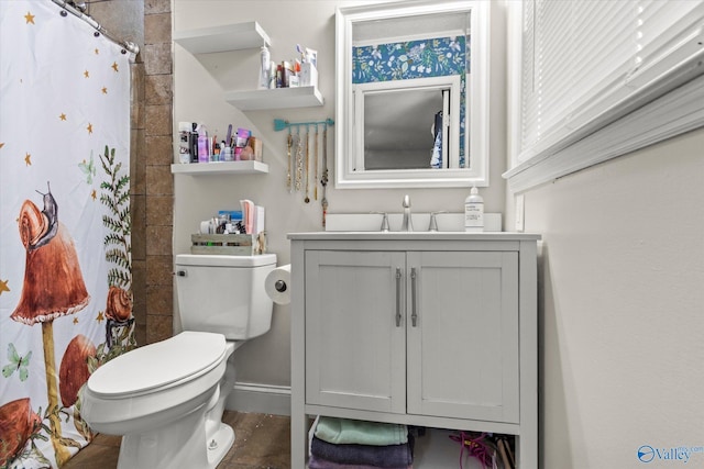 full bathroom with curtained shower, vanity, toilet, and baseboards