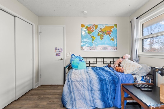 bedroom with a textured ceiling and dark wood-type flooring