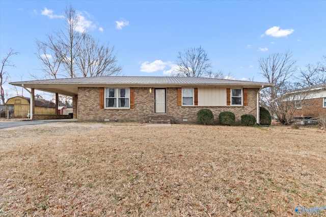 single story home with crawl space, metal roof, a carport, and brick siding