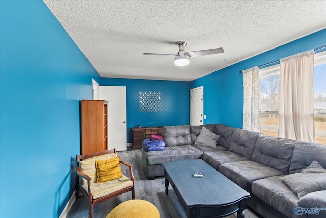 living room with a textured ceiling, dark wood-type flooring, and a ceiling fan