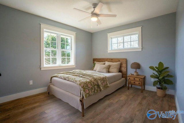 bedroom with a ceiling fan, wood finished floors, and baseboards
