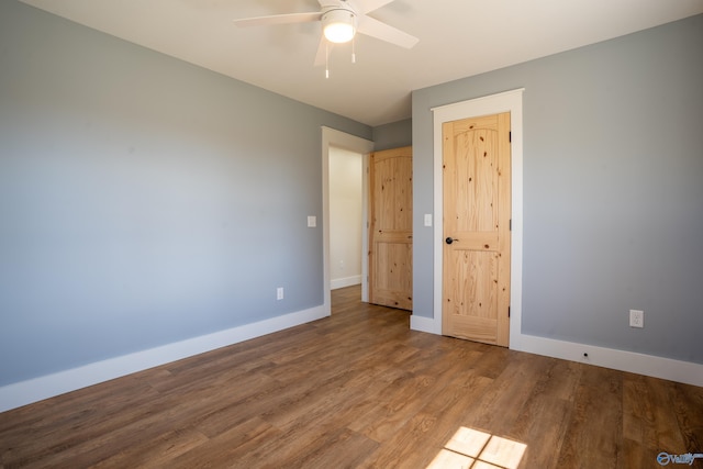 unfurnished bedroom with a ceiling fan, wood finished floors, and baseboards