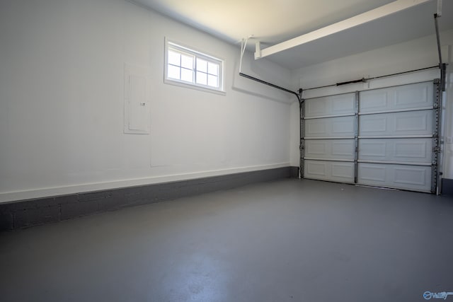 garage featuring electric panel and baseboards