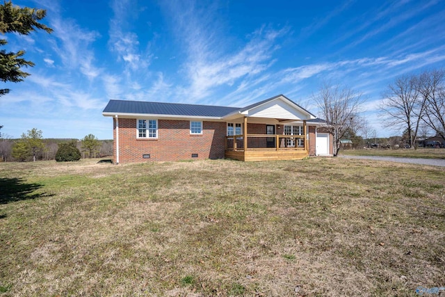 view of front of house featuring a front lawn, metal roof, brick siding, and crawl space