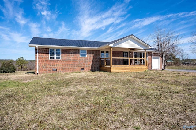 view of front facade with a front yard, metal roof, brick siding, and crawl space