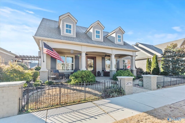 new england style home with ceiling fan and covered porch